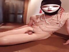 A man wearing a mask binds his body by himself